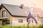 Mann springt in die Luft vor einem Haus
